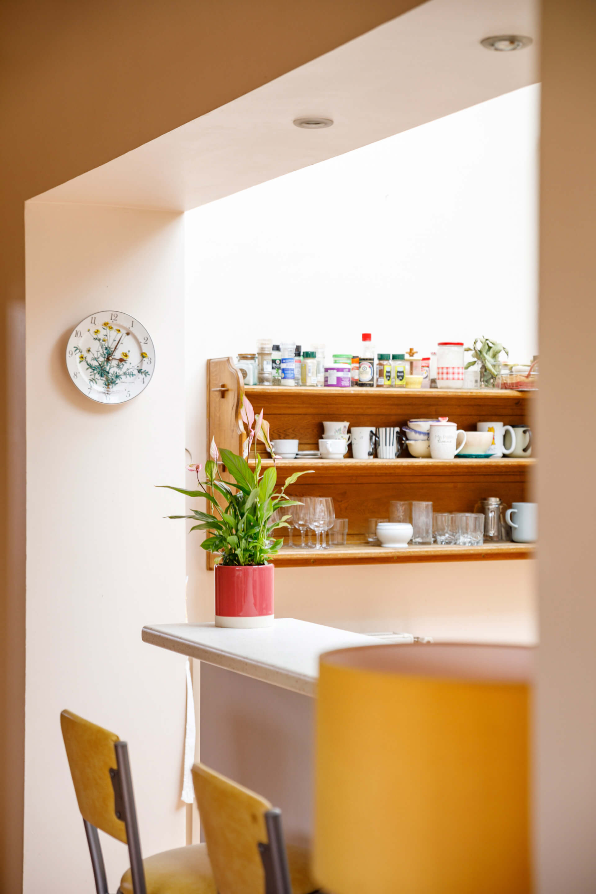 Bright kitchen with chairs and shelves on the wall