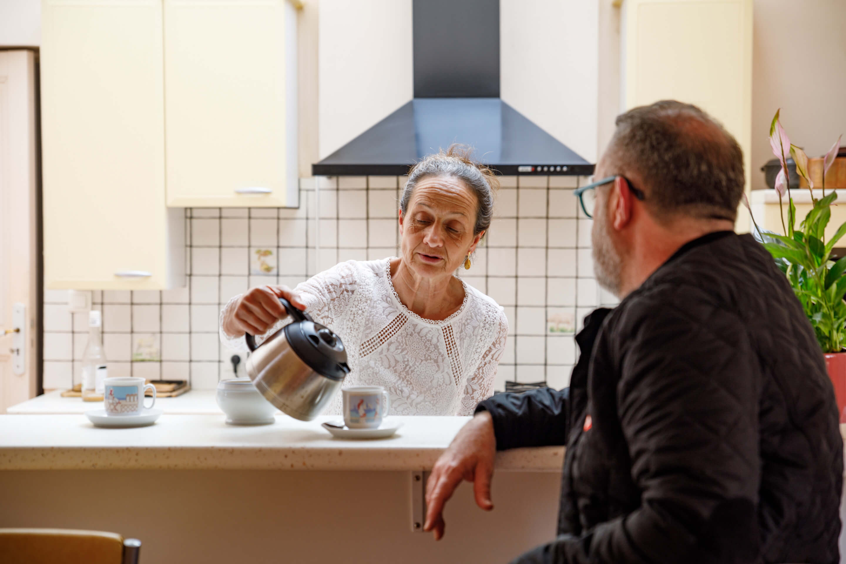 Woman and man having a cup of coffee in a kitchen