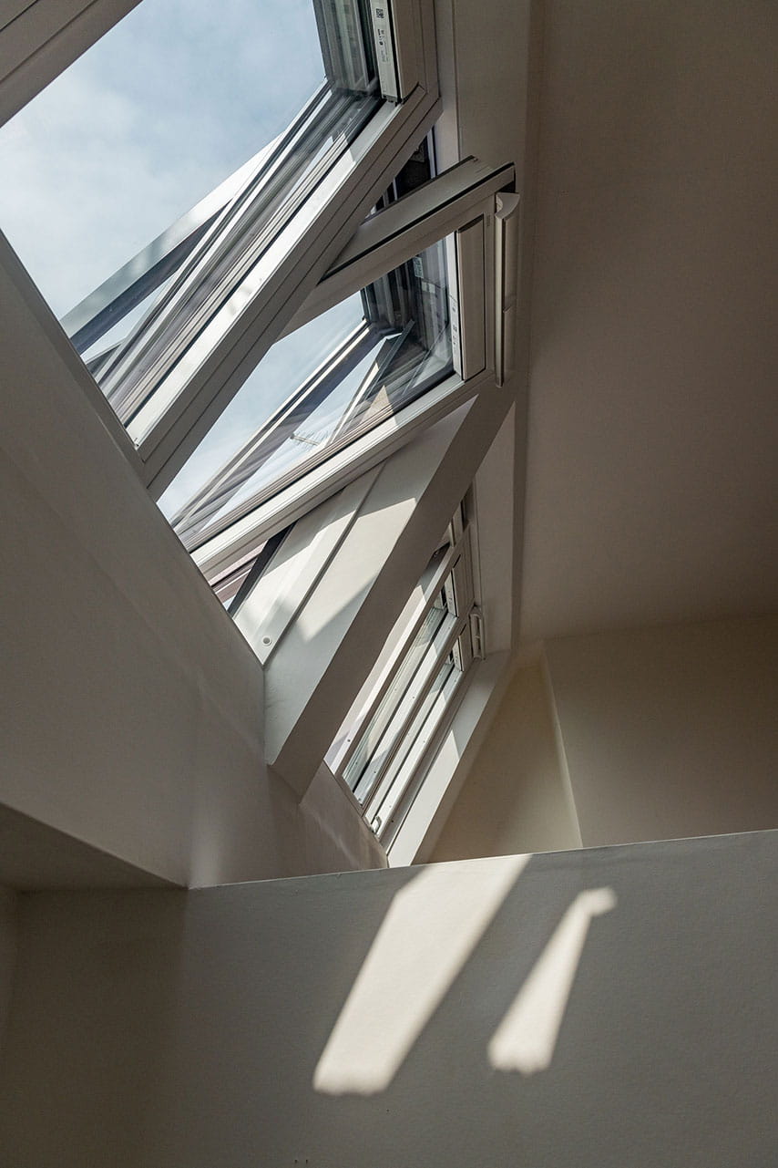 A hushed rooftop room in London-sunlight shining in through roof windows