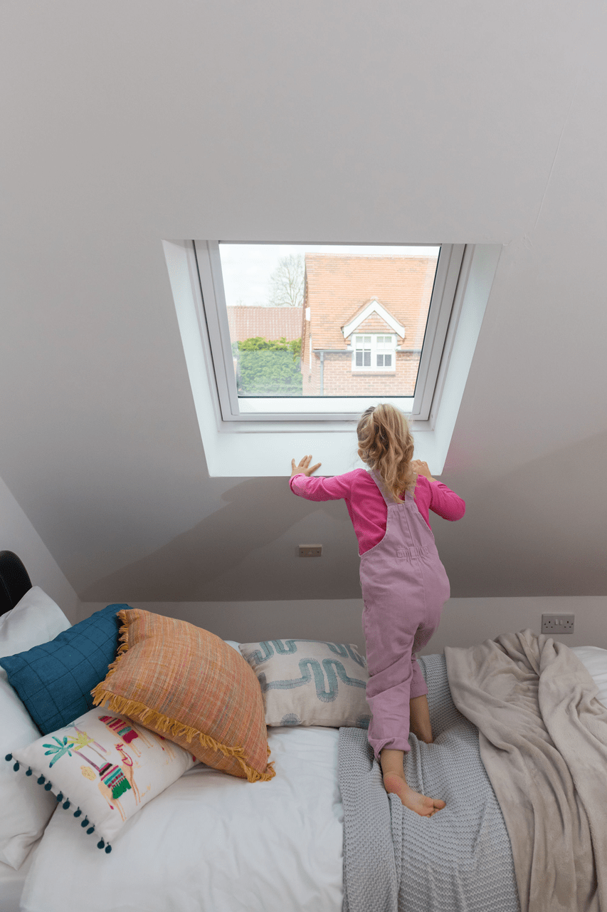Designing an energy-efficient living space with roof windows-child looking out of window