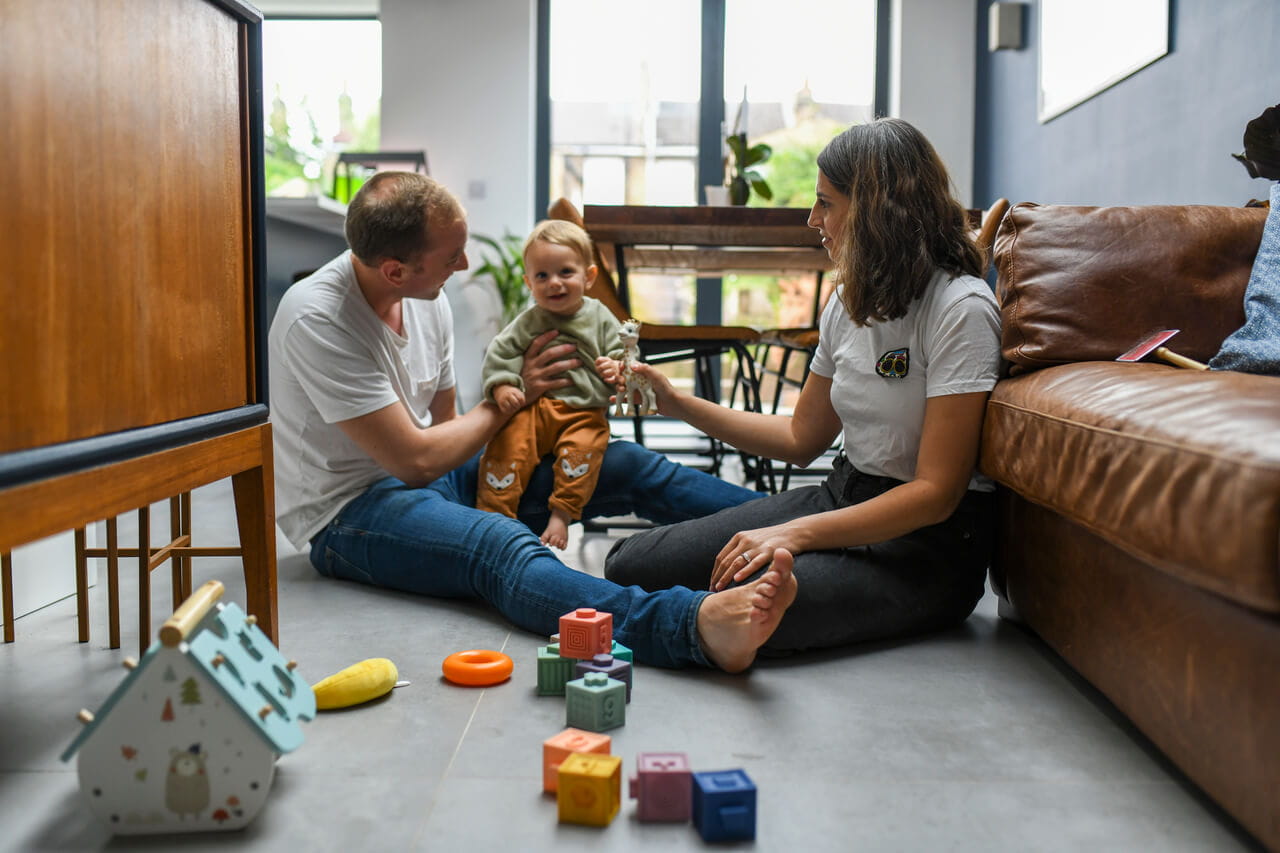 A family playing with baby in the living room.
