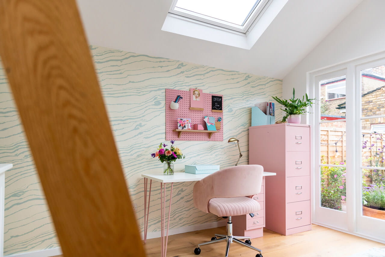 A bright and colourful home office area with a roof window.
