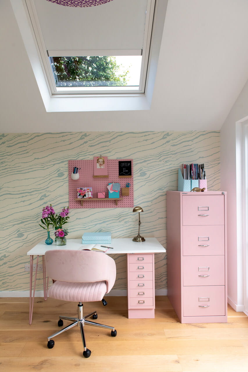 Home office corner with pink table, pink chair and pink cabinet.