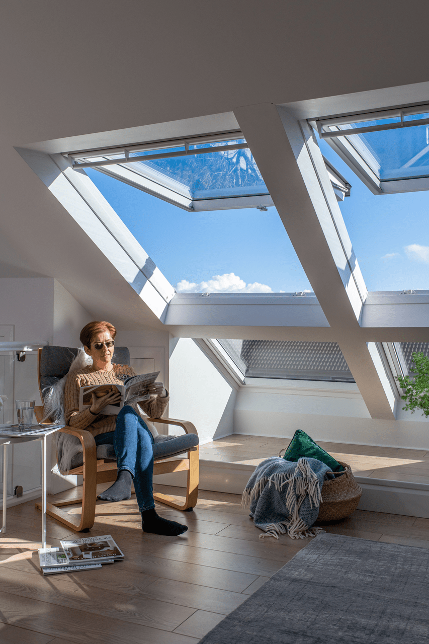 How to realise the potential of your attic space with roof windows - woman sitting by window