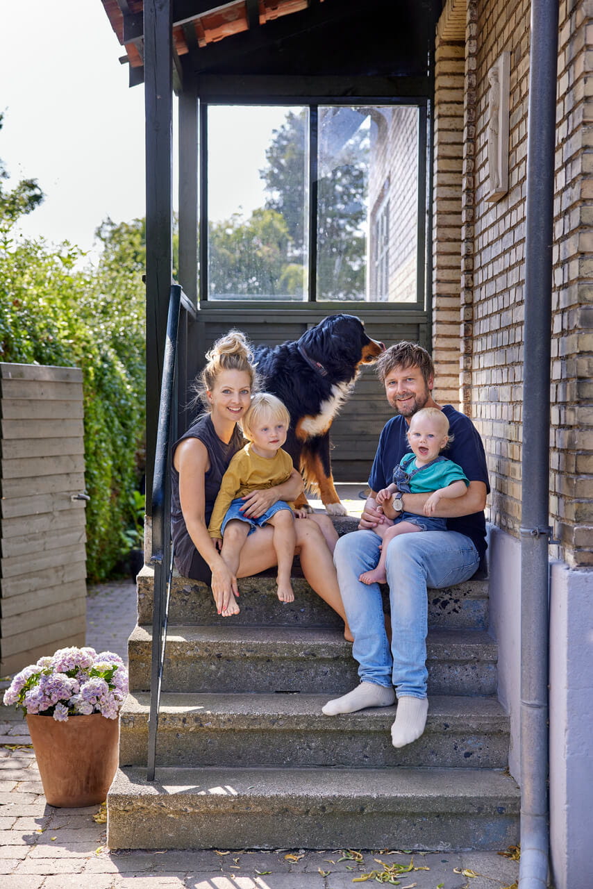 A family sitting outside the house on the front strairs
