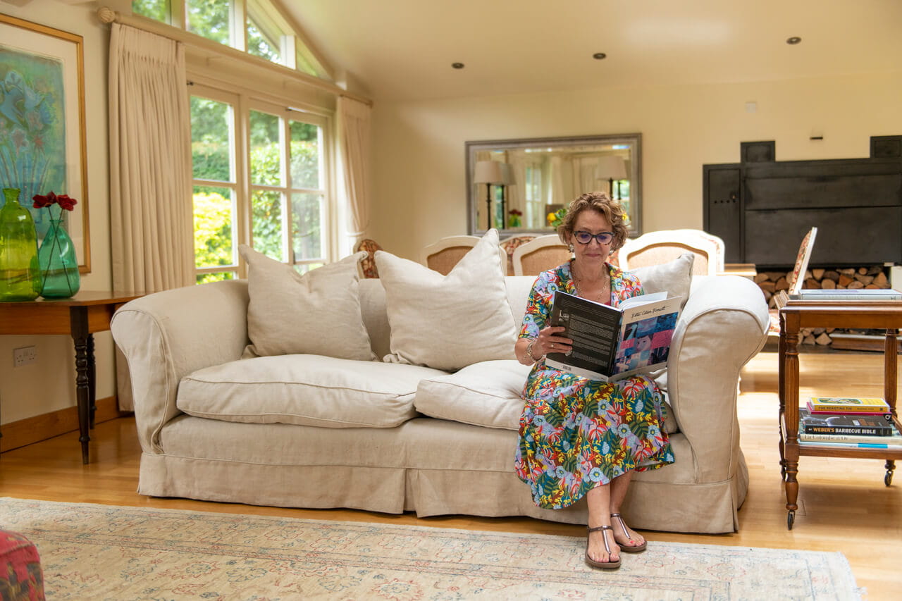 A woman reading the book while sitting on a sofa