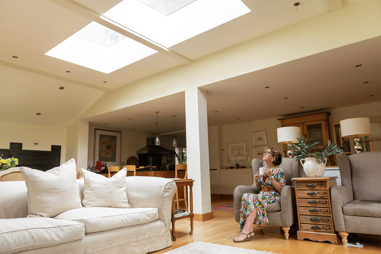 a new roof rejuvenates a living space-seated woman gazing up at roof window above
