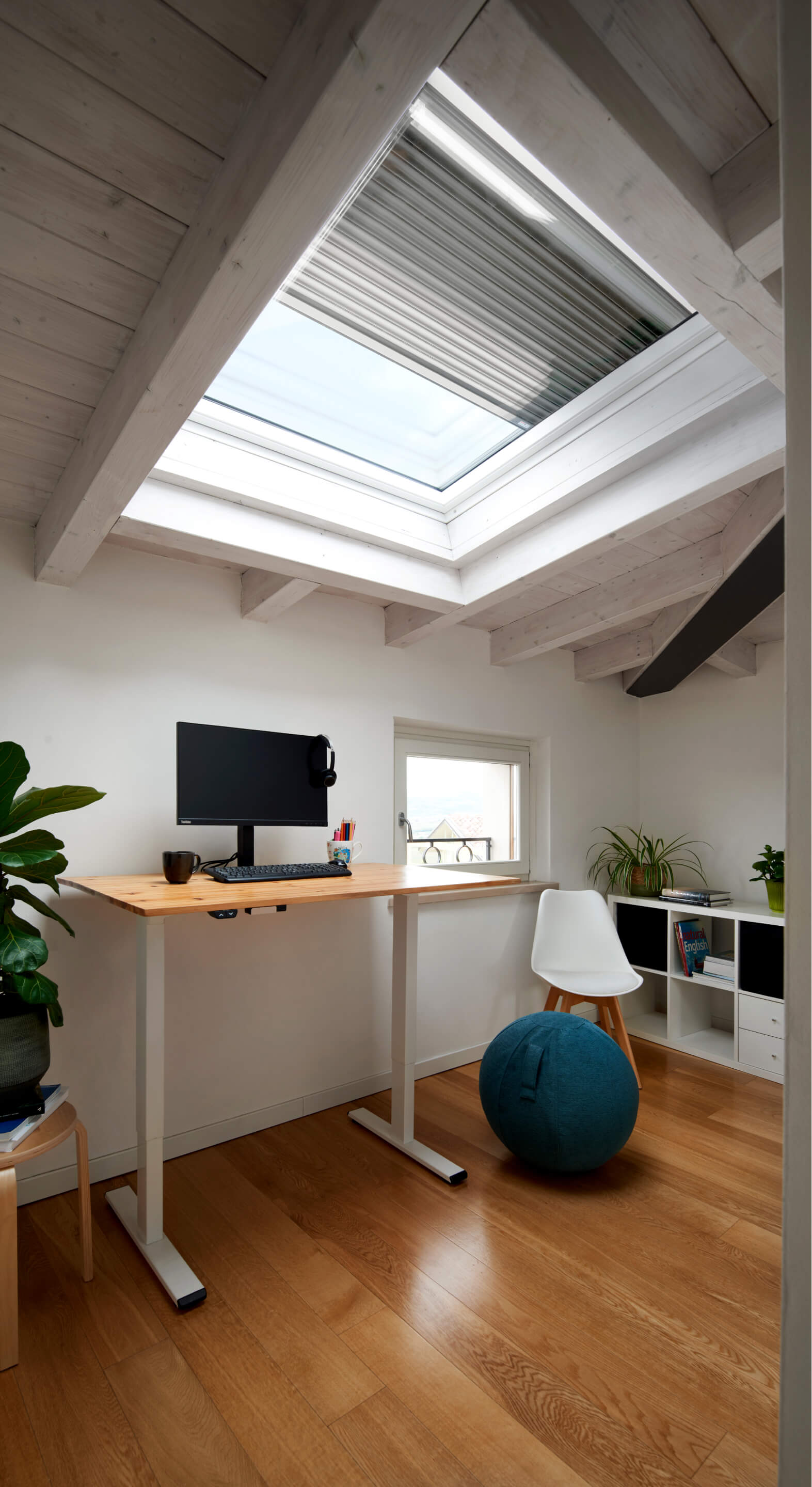 Home office space with roof window and blinds