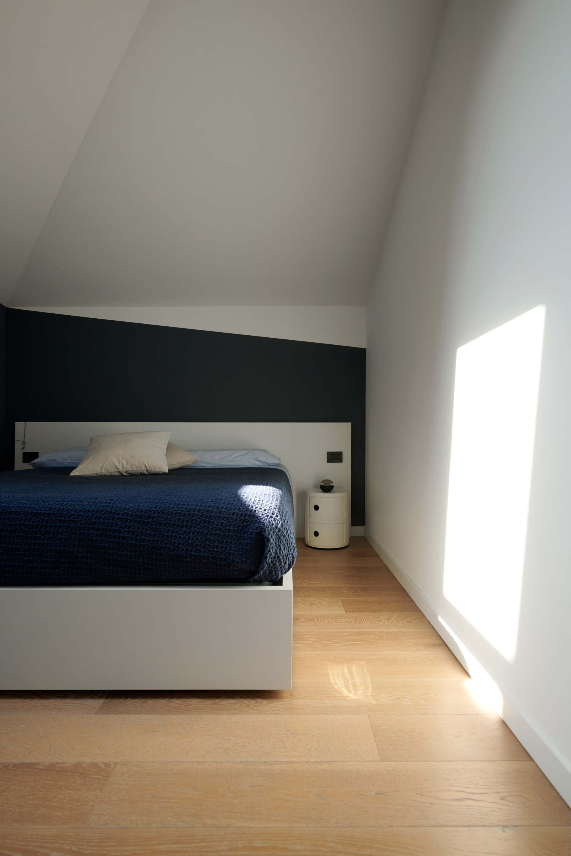 A bedroom area with bed and white walls