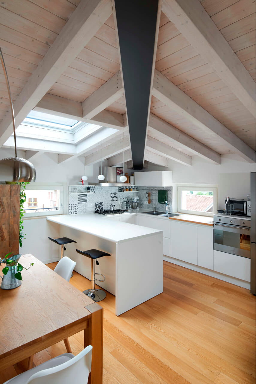 A kitchen in the attic with a roof window
