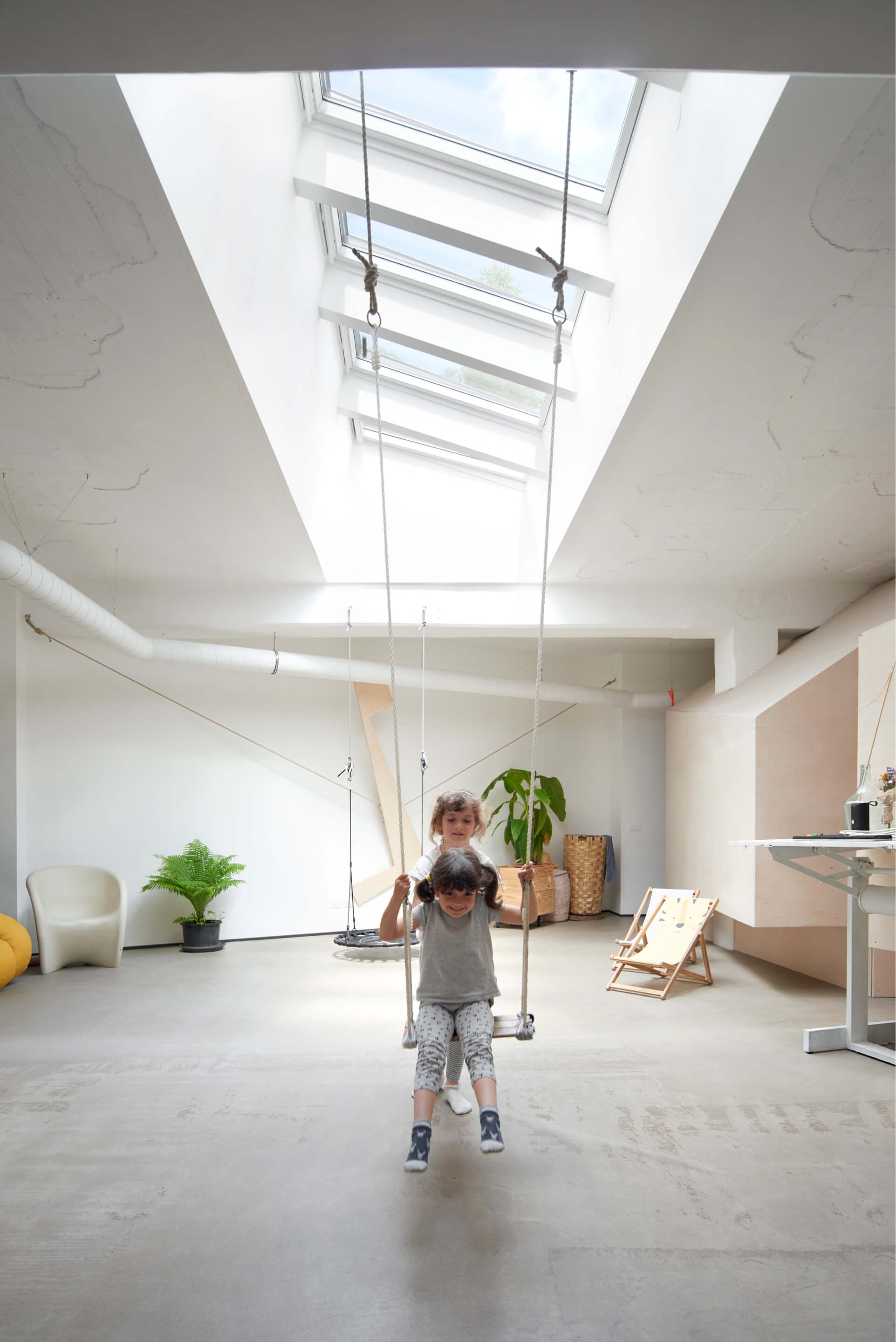 Room with lot of lights and roof windows with children playing