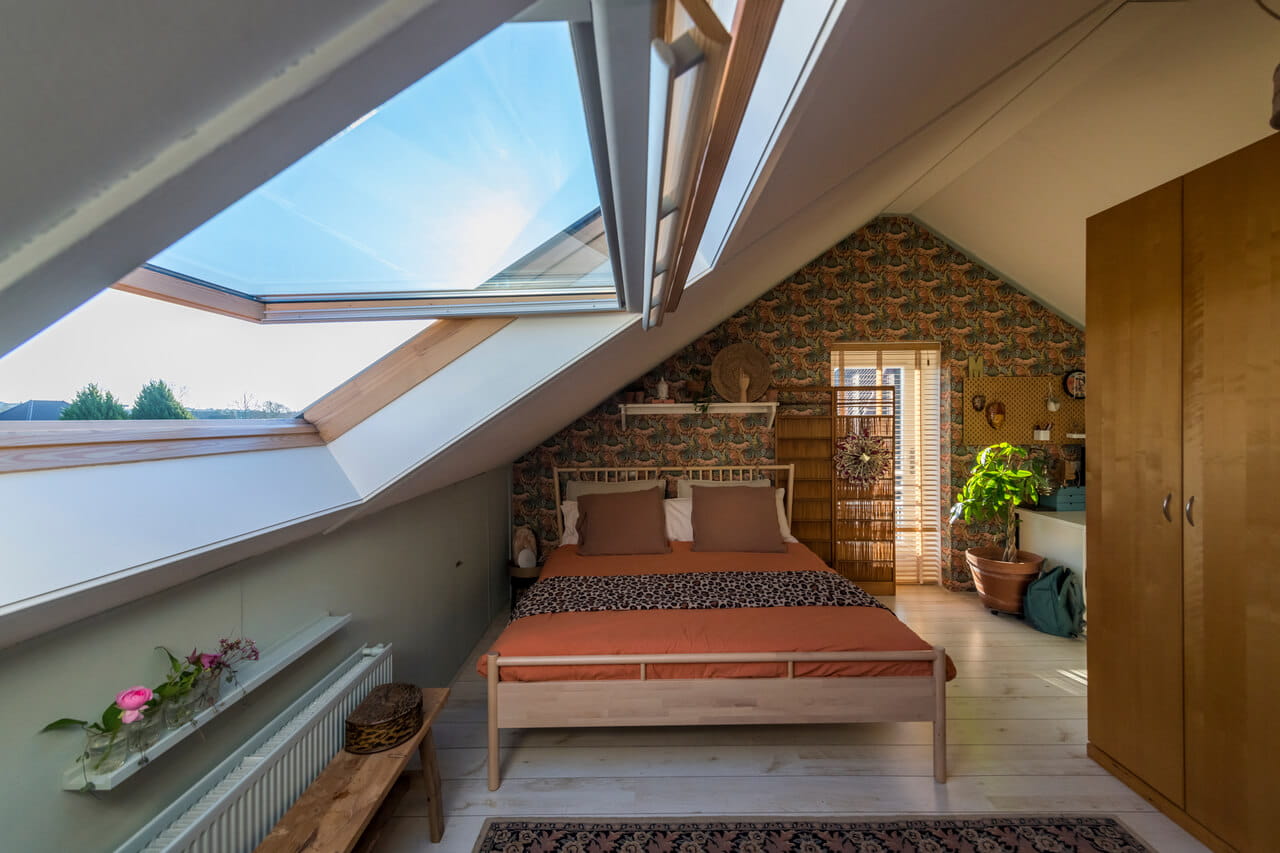 A retro style bedroom in the attic with a roof window.